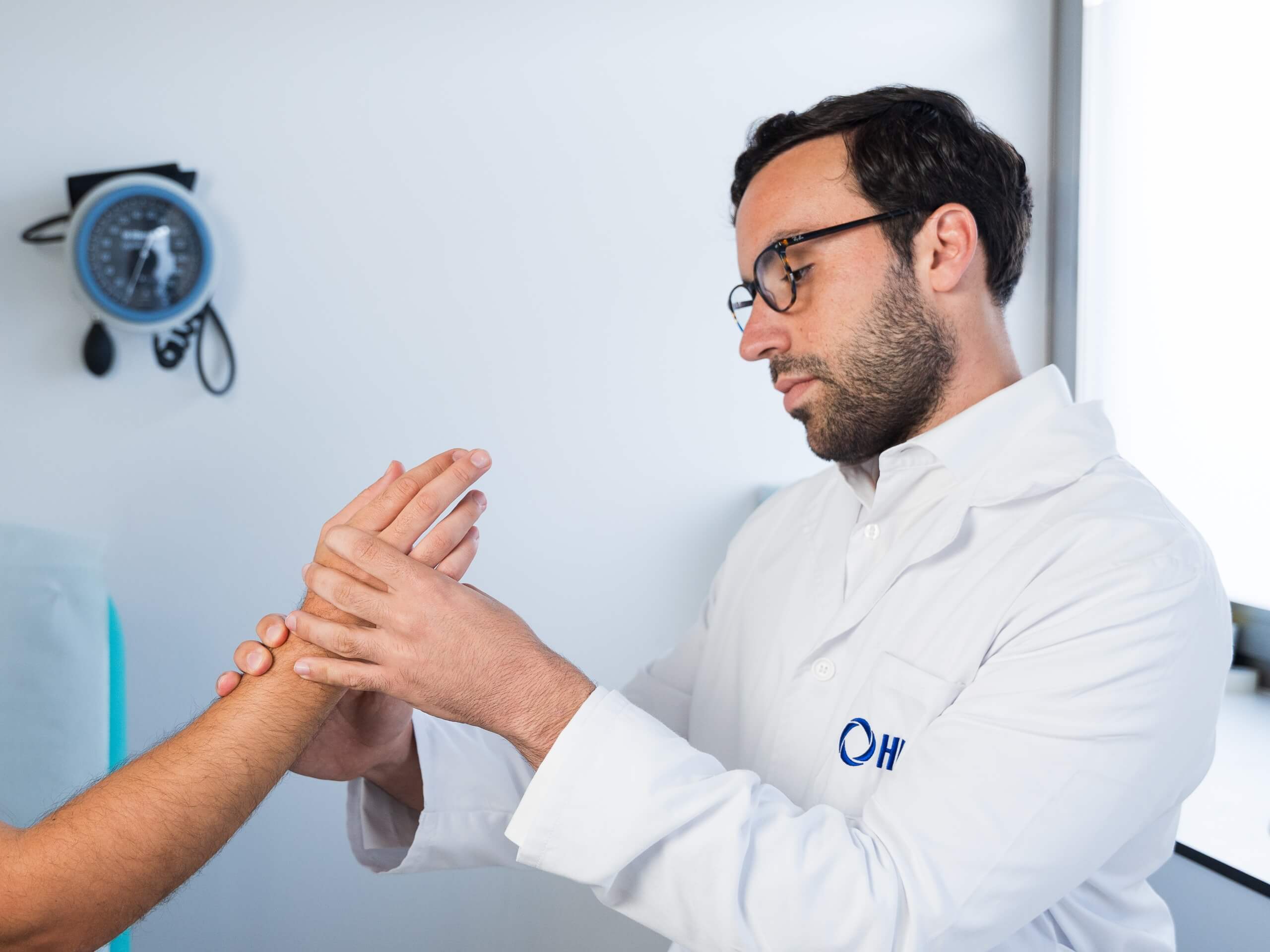 El doctor Alejandro Moriel examinando una mano en su consulta